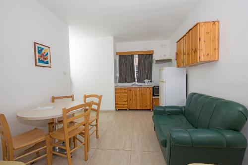 un soggiorno con un divano verde e un tavolo di Cardor Holiday Complex a San Pawl il-Baħar