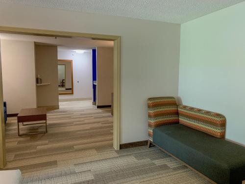 a waiting room with a couch and a chair at Holiday Inn Express & Suites Lexington Downtown Area-Keeneland by IHG in Lexington