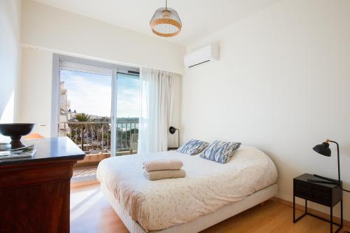 une chambre avec un lit et une grande fenêtre dans l'établissement Violet, bord de mer, à Cannes