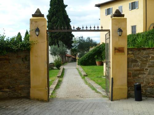 an open gate leading into a garden with a driveway at Villa Morghen in Settignano