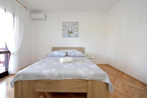 比比涅的住宿－Apartmani Jagoda，一间卧室配有一张带白色床单的大床
