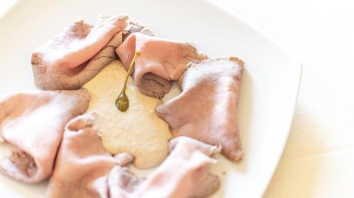 a plate of food with meat and a spoon at Agriresort Villa Gelso- Adults Friendly in Vesime