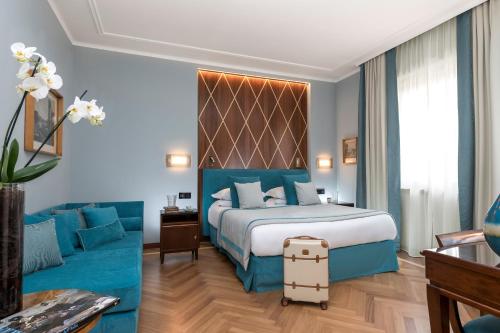 a hotel room with a king sized bed and a couch at Bettoja Hotel Mediterraneo in Rome