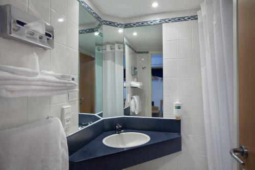 a bathroom with a sink and a mirror at Holiday Inn Express Geneva Airport, an IHG Hotel in Geneva