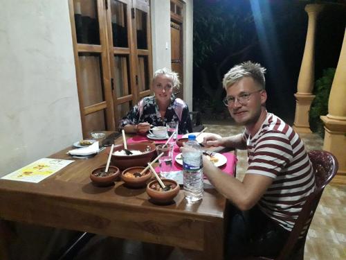 a man and a woman sitting at a table at Shan Mango Homestay in Sigiriya