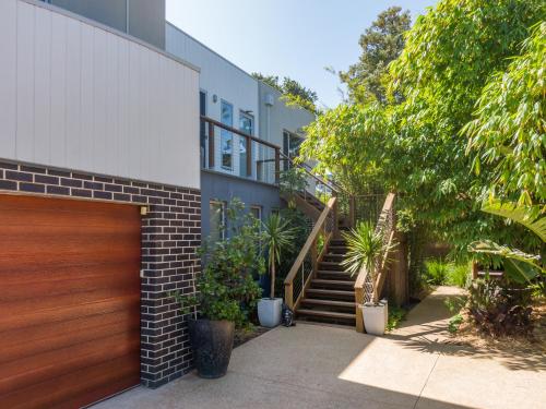 a house with a wooden garage door and some plants at Serenity Guest House in Dromana