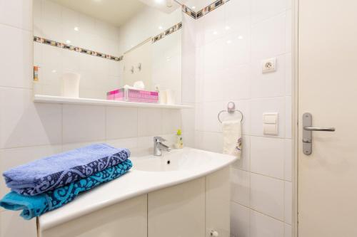 une salle de bain blanche avec un lavabo et une douche dans l'établissement Violet, bord de mer, à Cannes