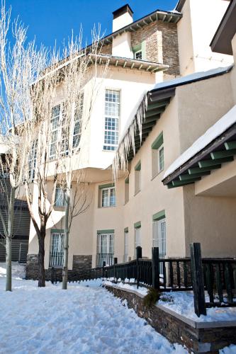 a building with snow in front of it at Hotel Apartamentos Trevenque in Sierra Nevada