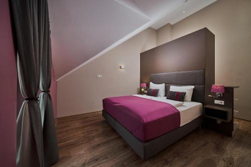 a bedroom with a large bed with a purple blanket at Villa Salzburg by Welcome to Salzburg in Salzburg