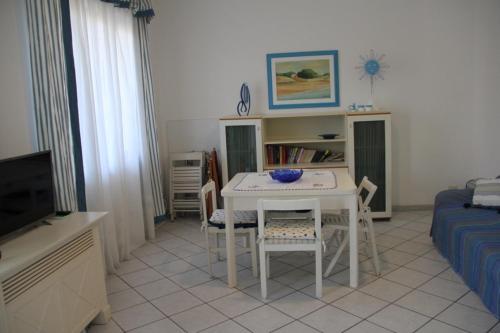 sala de estar con mesa blanca y sillas en Sottovento, en Marina di Modica