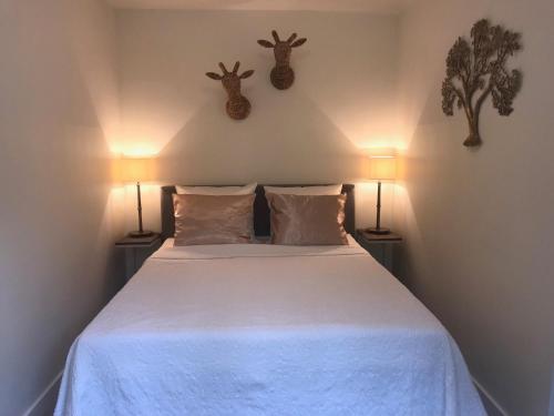1 dormitorio con 1 cama con 2 cabezas de ciervo en la pared en Natuurpark Hoefbos Boshuisje Veluwe, en Otterlo