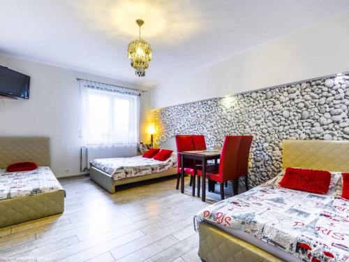 Cette chambre comprend deux lits, une table et des chaises. dans l'établissement Pokoje gościnne "Lenka", à Ciechocinek