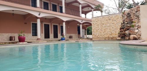 a swimming pool in front of a building at Hotel Los Frailes, Valladolid, Yucatán in Valladolid