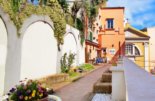 un callejón en una ciudad con flores y edificios en Il Borghetto Apartments & Rooms en Procida