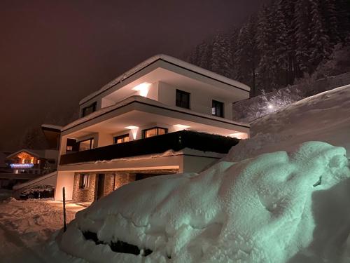a house with a pile of snow in front of it at see.view apartment in See
