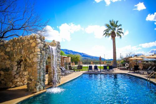 a swimming pool with a waterfall in a resort at Tanque Verde Guest Ranch in Tucson