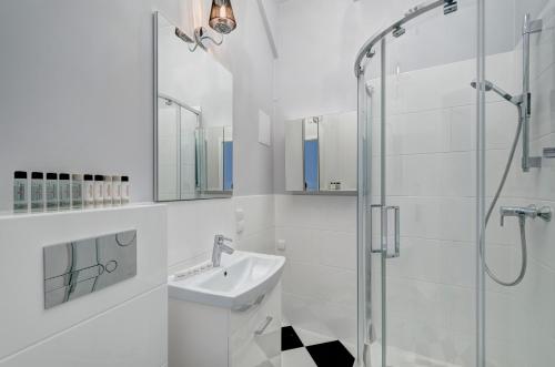 ソポトにあるDom & House Apartment Monte Cassino 21の白いバスルーム(シンク、シャワー付)