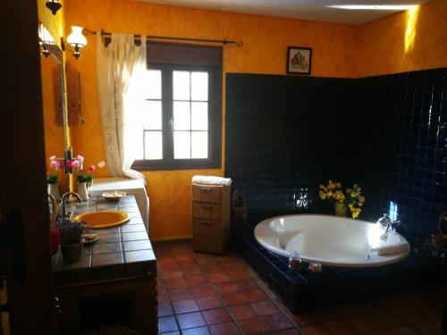 Un baño con una bañera grande y una ventana. en Mi morada, en Mijas