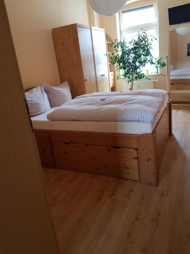 a bed with a wooden frame in a room at Kleine gemütliche Ferienwohnung in Dresden