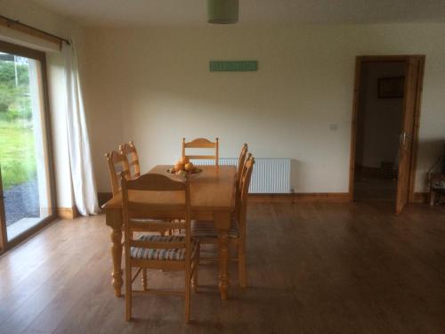 a dining room with a table and chairs with a fruit on it at Achill Alantic Dream in Derreen