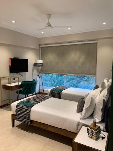 um quarto com 2 camas e uma grande janela em Theory9 Premium Service Apartments Bandra em Mumbai