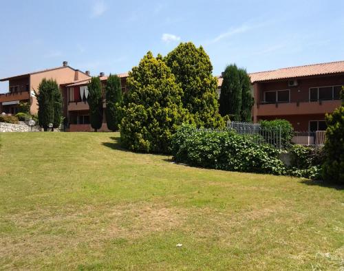 um quintal em frente a um edifício com árvores em Appartamento Filippo em Castelnuovo del Garda