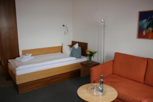 Habitación con cama, sofá y mesa. en Bildungs- und Begegnungsstätte Brüderhaus en Rothenburg