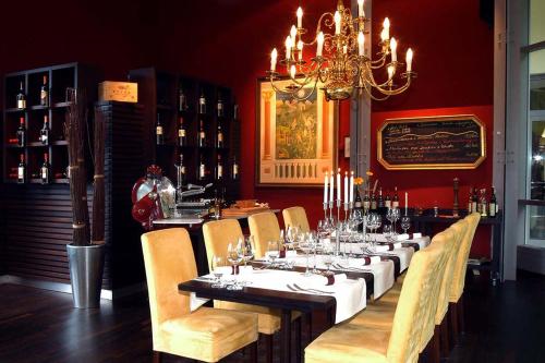 uma sala de jantar com uma mesa longa com cadeiras e um lustre em Bildungs- und Begegnungsstätte Brüderhaus em Rothenburg