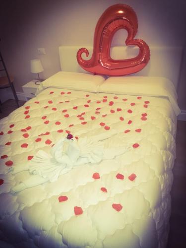 a wedding cake with hearts on a bed with a sign at Carpe Diem in Lamezia Terme