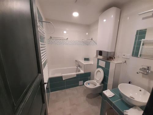 a bathroom with a sink and a toilet and a tub at Apartmány pod Mariánskými schody in Albrechtice v Jizerských horách