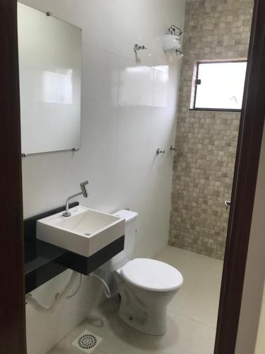 a bathroom with a white toilet and a sink at Rancho Chega Mais 2 in Carmo do Rio Claro