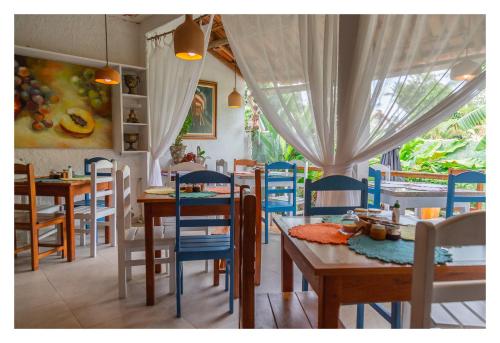 a dining room with tables and blue chairs at Pousada Cravo e Canela in Arraial d'Ajuda