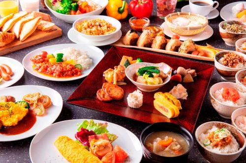 a table topped with plates of food and bowls of food at HOTEL FORZA HAKATAEKI CHIKUSHIGUCHI Ⅱ in Fukuoka