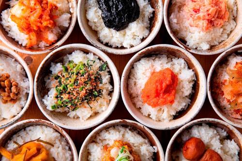 a bunch of bowls filled with rice and vegetables at HOTEL FORZA HAKATAEKI CHIKUSHIGUCHI Ⅱ in Fukuoka