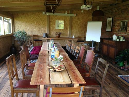 einen langen Holztisch und Stühle in einem Restaurant in der Unterkunft Landhof zur Meierei in Penzlin