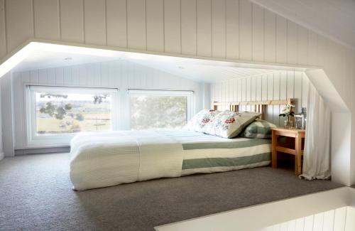 um quarto com uma cama grande e uma janela em Extraordinary Huts Ltd em Rye