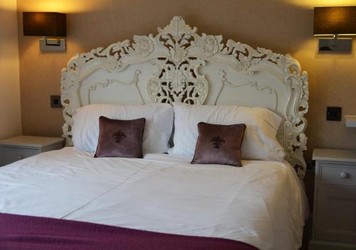 a large white bed with two pillows on it at The Bell in Shifnal