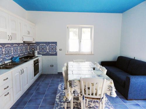 a kitchen and living room with a table and a couch at Cavadozza by Caseaponza it in Ponza