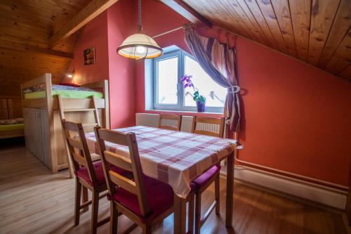 a dining room with a table and chairs and a window at Penzion u Vichu in Červená Voda