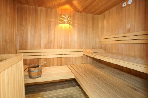 a wooden sauna with a bucket in the middle at Al Sole Clubresidence in Canazei
