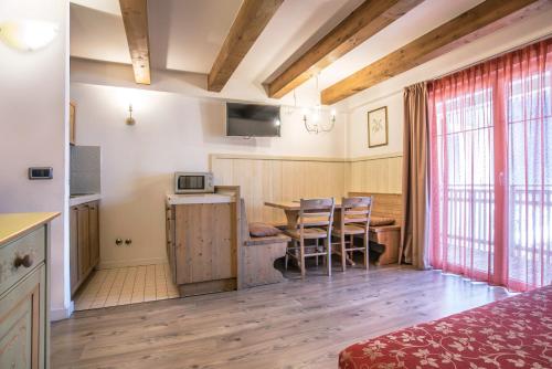 a room with a kitchen and a table with chairs at Al Sole Clubresidence in Canazei