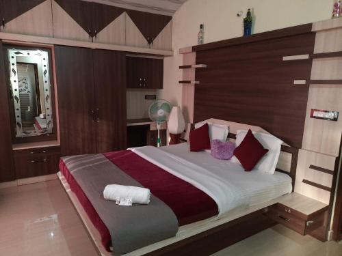 a bedroom with a large bed with red pillows at Srinikethana Home Stay with Swimming Pool in Madikeri