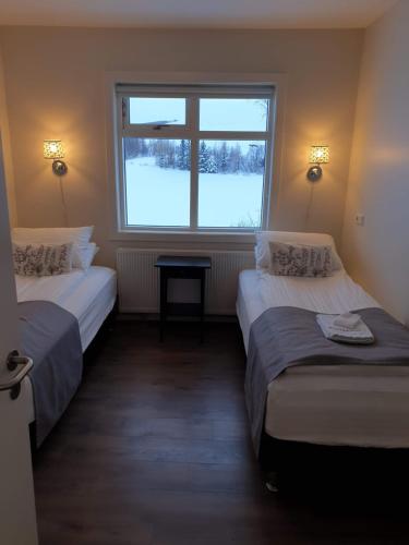 Breidamyri Farm Apartments في لاوغار: سريرين في غرفة مع نافذة