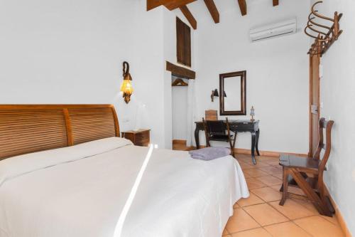 a bedroom with a white bed and a desk at Es Tarongers in Sóller