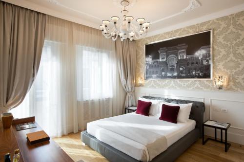 Un dormitorio con una cama grande y una lámpara de araña. en Suite Milano Duomo, en Milán