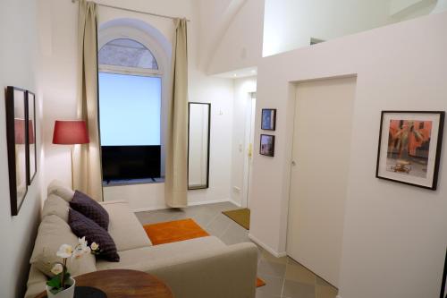 salon z białą kanapą i oknem w obiekcie Apartments near Augarten w Wiedniu