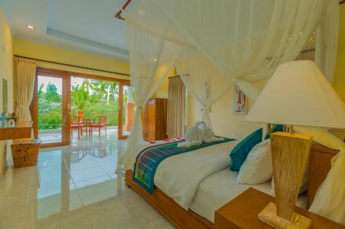 una camera da letto con un letto con una lampada e un tavolo di Tantra House Ubud ad Ubud