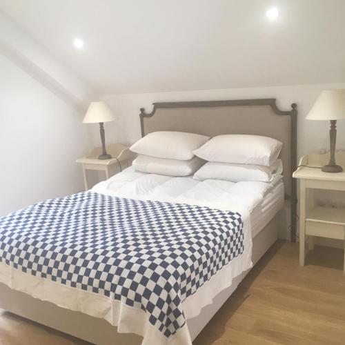 - un lit blanc avec une couverture en damier bleu et blanc dans l'établissement Farmhouse in a working winery with vineyard views, à Marigny-Brizay