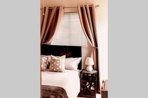 The Smiths Self Catering Cottage في كيب تاون: غرفة نوم بسرير ونافذة