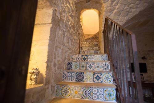 a staircase with blue and white tiles on the wall at SI-Moutique Le Case degli Avi barocche, con terrazza panoramica in Modica